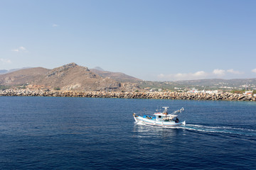 fishing boat in the sea on a background of mountains