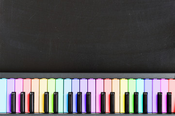Colorful music keyboard on blackboard background for music school children with copy space