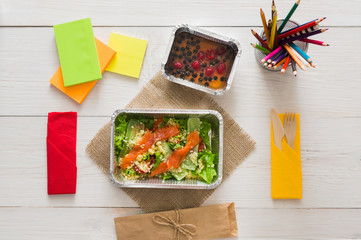 Healthy food in foil box on working table, diet concept.