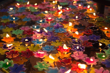 The flower candles floating in water use for make merit in the Buddhist, colors of the day are the traditional Thai birthday colors.