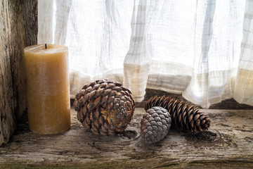 three pinecones and a candle