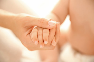 Fototapeta na wymiar Mother holding baby hand, closeup