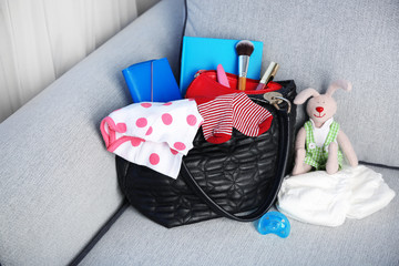 Mothers bag with accessories on couch