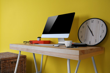 Working place on yellow wall background