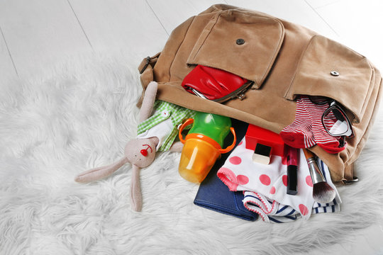 Mothers Bag With Accessories On Carpet