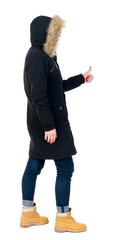 Naklejka premium Back view of woman thumbs up. girl in warm winter jacket is black with cancer and shows thumb up.
