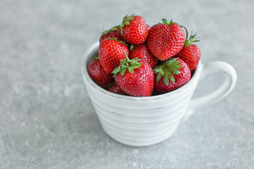 Fresh strawberries in cup on table