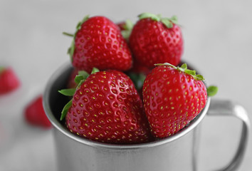 Fresh strawberries in cup on table