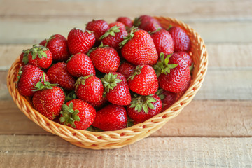 Fresh strawberries in wicker basket on table