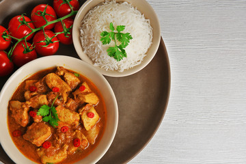 Tasty dinner with chicken curry in plate on tray