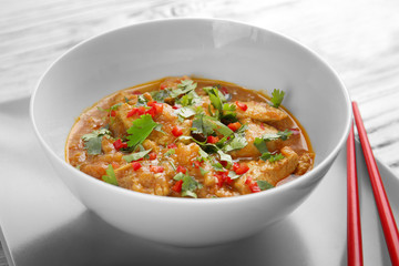 Tasty chicken curry in plate and chopsticks, closeup
