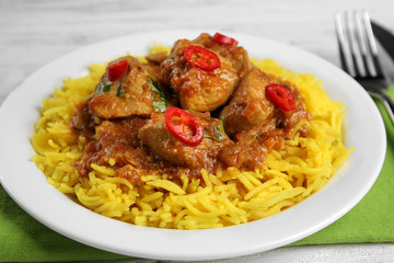 Tasty dinner with chicken curry and rice on plate, closeup