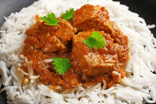 Tasty dinner with chicken curry and rice on plate, closeup