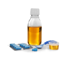 Baby syrup with spoon and pills, isolated on white
