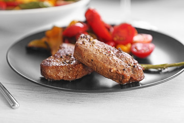 Delicious steak with vegetables on dinner table