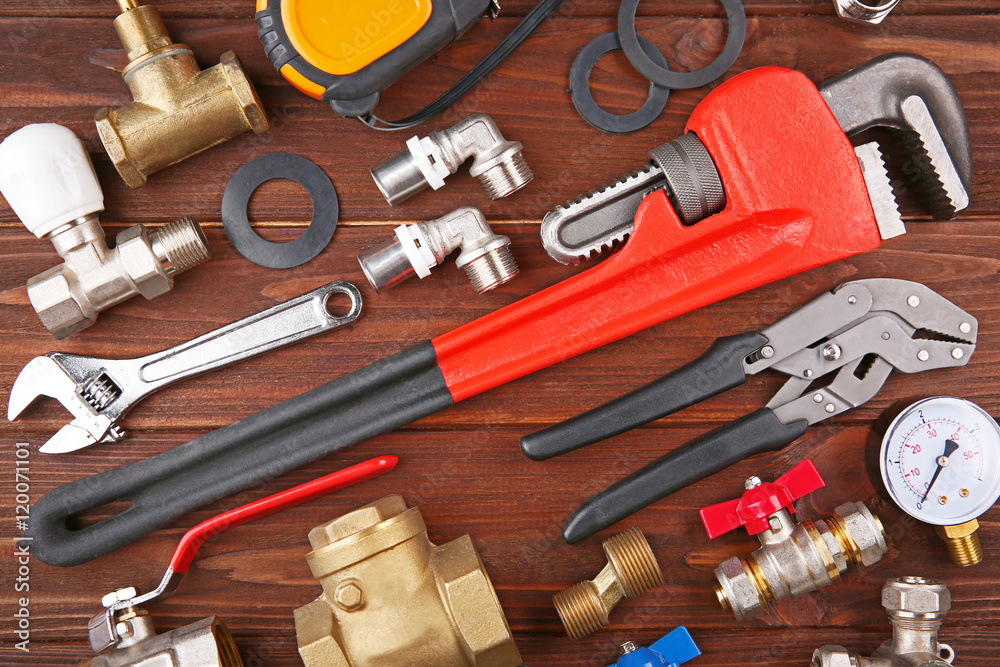 Wall mural Plumber tools on a wooden background