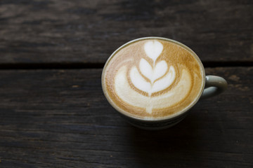 Coffee late art on dark wooden floor