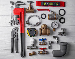 Plumber tools on white wooden background