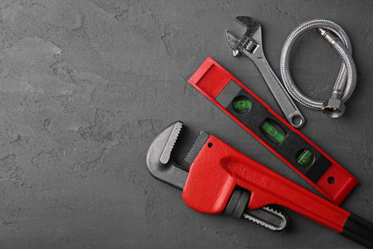 Plumber tools on concrete structure background