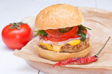 hamburger cheese onions sauce tomatoes on paper