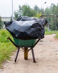 Two large black rubbish bag lying on the handcart