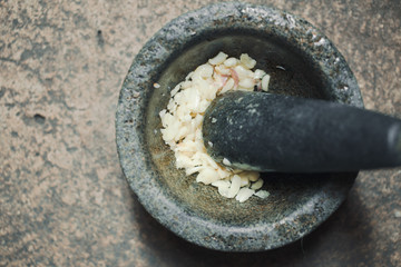 Fototapeta na wymiar Thai garlic with mortar and pestles homemade paste spicy herb ingredient of Thai food.