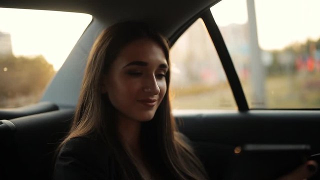 Beautiful woman tourist traveling in a taxi and rewritten with your friends on your phone