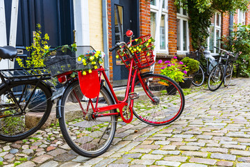 Fototapeta na wymiar Retro vintage red bicycle on cobblestone street in the old town.