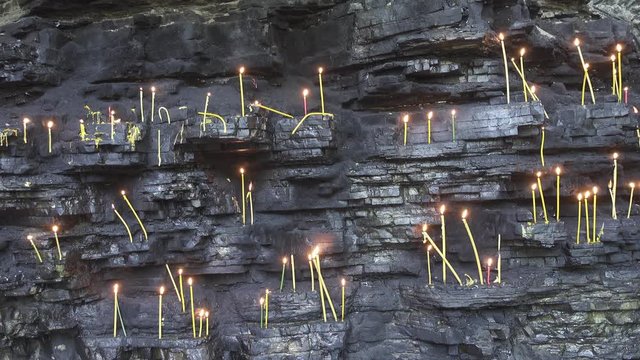 Christian holy place - candles in grotto, 4k