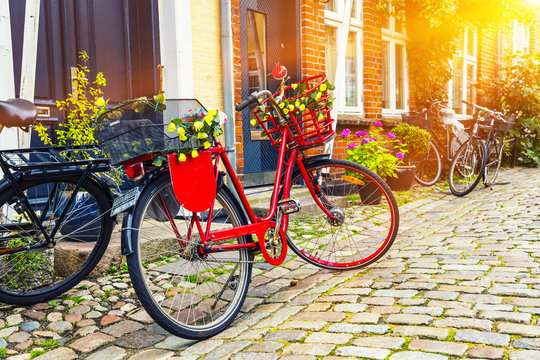 Retro vintage red bicycle on cobblestone street in the old town