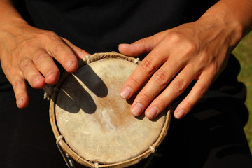 Close up of hands of a woman playing a drum