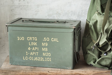 still life photography : Old and dusty bullet box ( ammo crate ) with part of Military backpack on old wood - obrazy, fototapety, plakaty