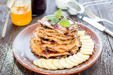 Stack of Healthy Oat Pancakes with Blueberry Jam, Banana and Maple Syrup
