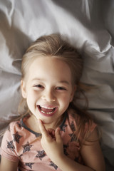 Girl laughing in her bed