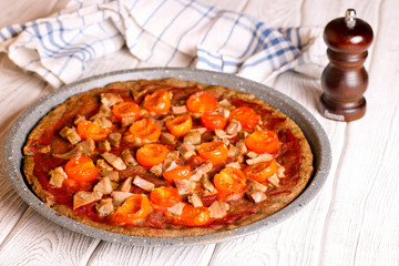 Pie with tomatoes and ham on a white table