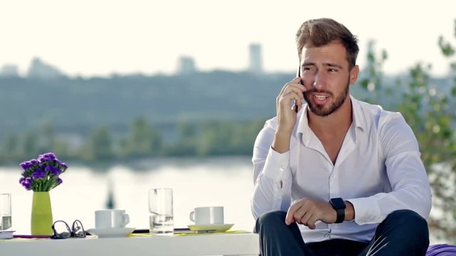 Handsome man talking on the phone outdoors