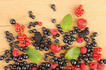Mix of different berries on a wooden background