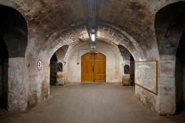 Fototapeta na wymiar Long underground brick tunnel in the wine cellar