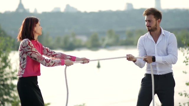 Business partners playing tug of war outdoors