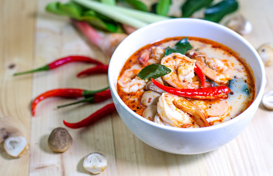 Tom yum kung, and condiment, on wooden table, Select focus