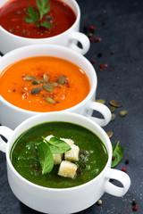 assortment of fresh vegetable cream soup on a dark background