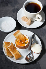 boiled egg, cup of coffee and crispy bread, top view