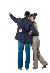 Young couple pointing at wall. Rear view. Isolated over white background.