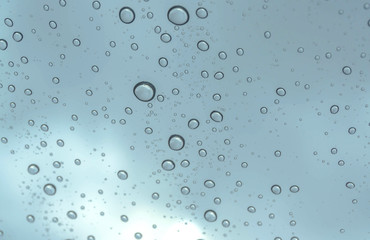 Fototapeta na wymiar Drops of rain on glass , rain drops on clear window / rain drops with clouds / water drops on glass after rain background / water drops / Small water drops on the glass.