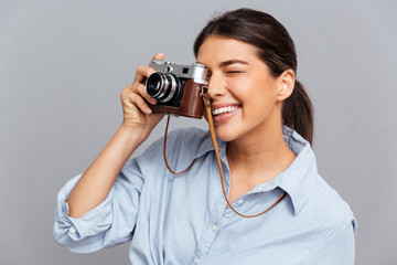 Portrait of a cheerful woman making photo with camera