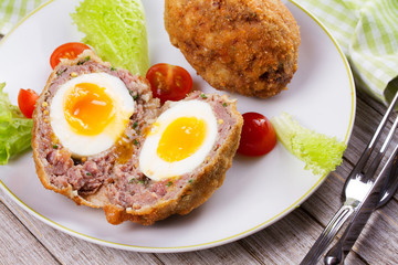 Scotch Eggs Served with Tomato Cherry and Salad on White Plate