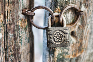 Old Rusty Decorated Padlock on a Wooden Door. Vintage Corroded Padlock on a Ancient Gate Background.