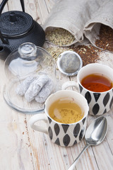 two cups 1 black tea rooibos and other fennel with teapot in the