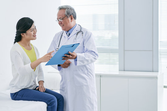 Asian doctor and patient discussing diagnosis or prescription