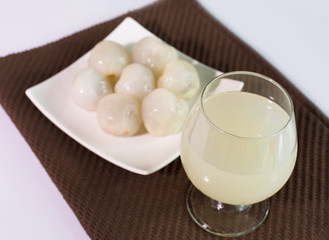 Fresh lychee juice in glass, on style blur
